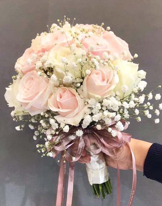 Bó hoa cưới cầm tay cô dâu mềm mại và dịu dàng từ hoa hồng phấn và hoa bi trắng